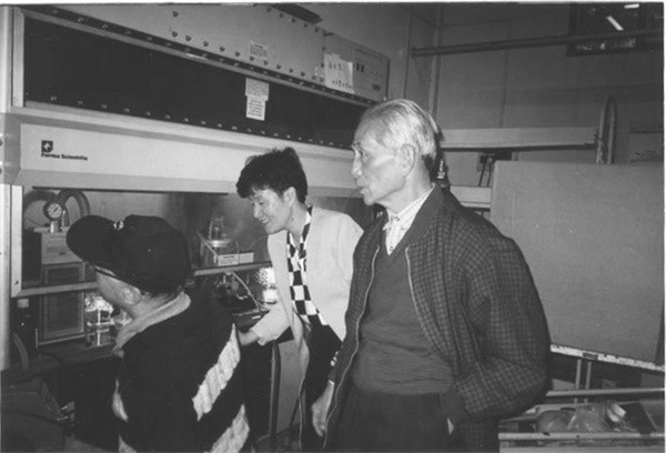 Chairman Fang Zhou discusses gene gun research with researchers from the Institute of Biophysics, Chinese Academy of Sciences, in 1999.